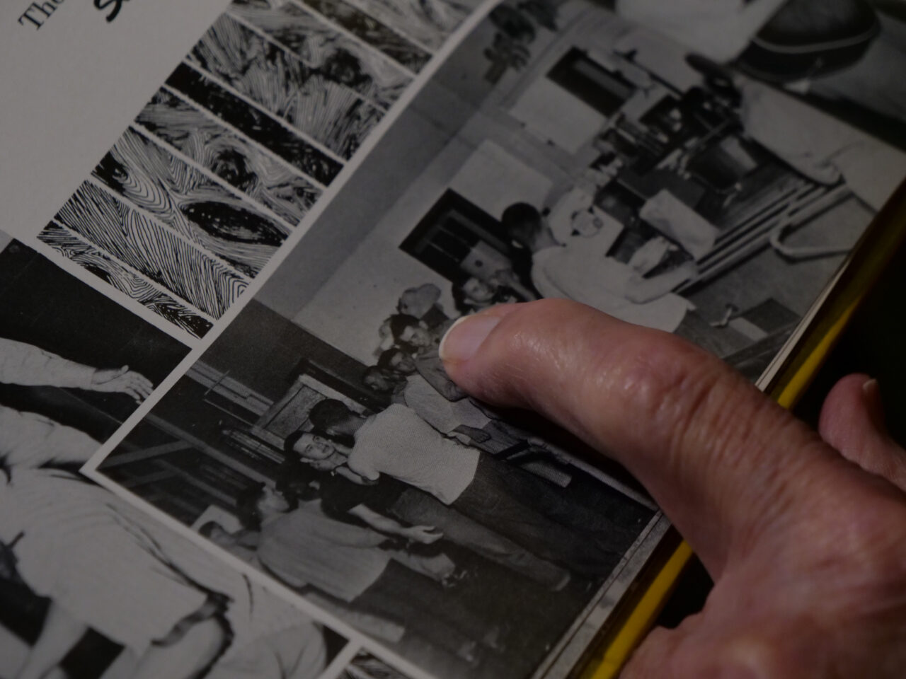 Tom Lambert looks through his unit's yearbook and points to himself in line. (Jeremy Long - WITF)