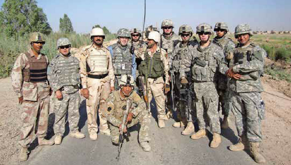 Former WITF journalist Scott Detrow (center) stands with members of the Pennsylvania National Guard's 56th Stryker Brigade and the Iraqi Army in summer of 2009. He was embedded with the unit as part of our Impact of War project.